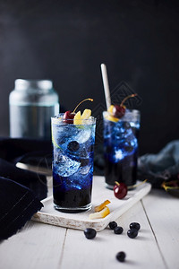 甜的饮料新鲜蓝莓鸡尾酒加柠檬皮和樱桃水果图片