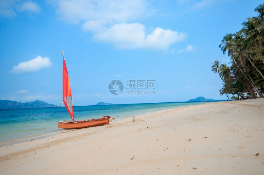 海滩上的橙色帆船图片