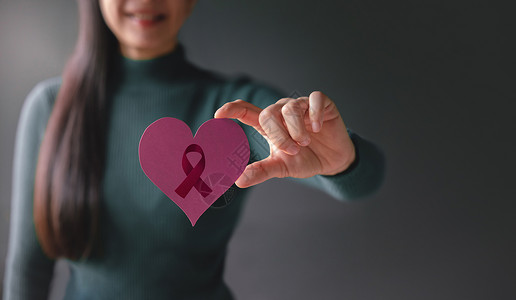 医疗保险标志医疗保险治世界爱保健癌症捐赠和慈善概念乳腺癌认识与带着症丝标志文件的怀有心脏形状的微笑志愿妇女与癌症丝带之心形密切接触背景