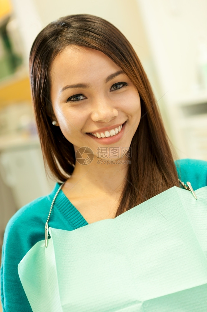 坐着卫生保健在牙医面前微笑的亚裔女看着镜头的照片看着镜头人类图片