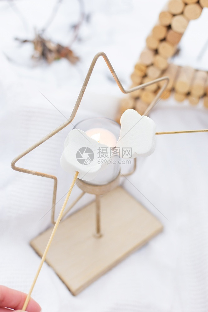 圣诞快乐新年在星蜡烛上烤棉花糖在星蜡烛外面烤棉花糖玩具甜的喜庆图片