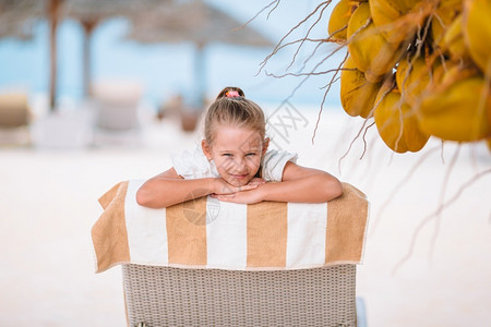 户外沙滩上趴在椅子上的小女孩图片