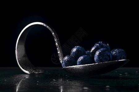 简约吃生的用蓝莓和深底水滴的蓝莓圆曲铬勺图片