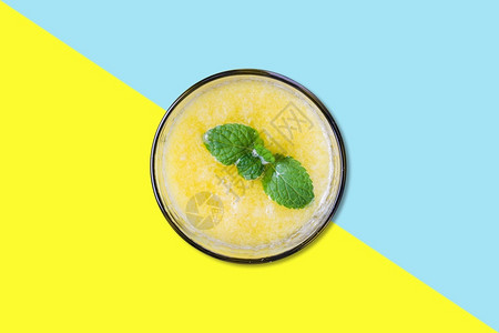 降低与薄叶平板立地概念隔离的小型杯子上芒果汁液体黄色的图片