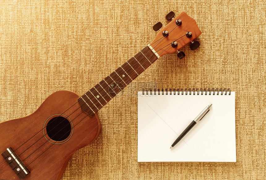 音乐索法的乌库莱勒最顶端风景有笔记本和用于设计工作尤克里图片