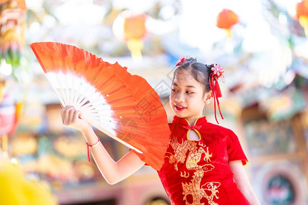 庆祝身着传统红宗山长相装饰的可爱亚洲小女孩在华神庙举办新年庆典风光盛会中文并举办范宁幸福背景图片