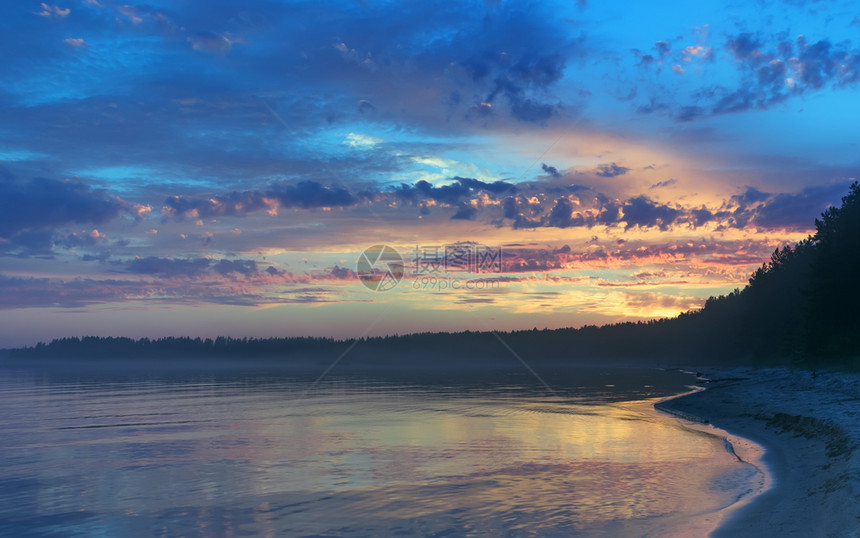 在俄罗斯卡利亚的白夜季节闪亮的空与日落时多彩的云朵在俄罗斯加里利亚奥尼加湖森林岸上的金色水面中反射蓝色的云景剪影图片