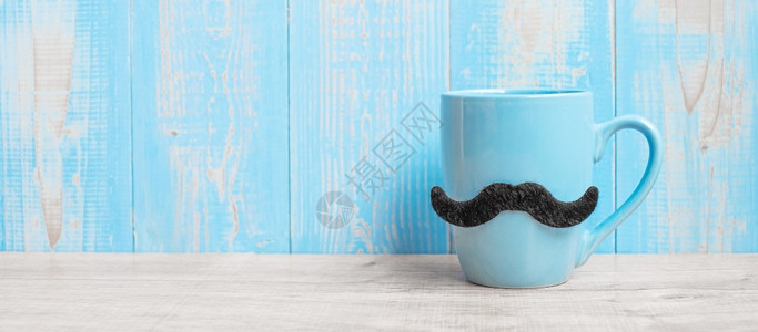 晨父日和国际男子概念在木桌背景上用黑胡子和的蓝咖啡杯举行生活象征九月图片