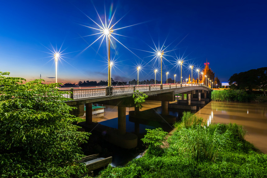 泰国Phitsanulok的Suphangkanlaya桥上路夜光交通灯的颜色建造蓝城市景观图片
