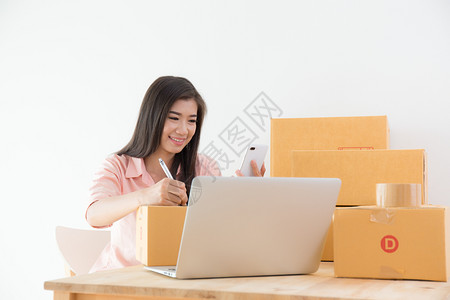 亚裔妇女微笑并记录客户订单企业在线营销概念网上售物流亚洲人工作图片