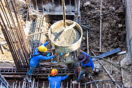 承包商将水泥倒入地基的工人在建筑地的区进行成形工作板坯流动图片