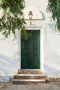 经典的封闭绿色教堂门上面有雕刻的装饰和灯笼外部的建筑学图片