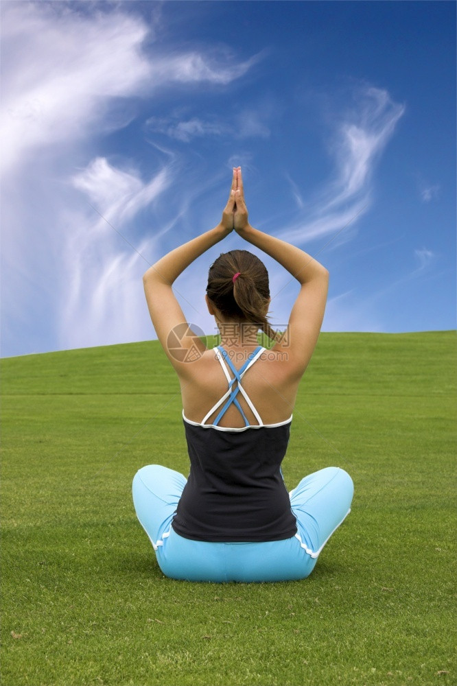 蓝色的锻炼灵魂美丽运动女子在美丽的绿草地上做瑜伽图片
