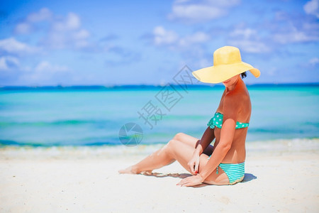 夏天在海滩晒太阳的年轻美女穿着帽子在海滩度假的年轻姑娘田园诗般的美丽图片