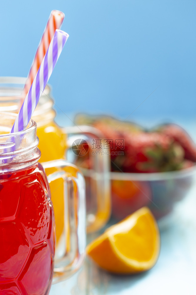 柔软的稻草两杯橙汁和蓝底草莓含橙汁和蓝底草莓图片