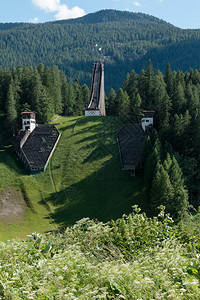 3米跳台之中阿尔卑斯山欧洲的夏季地风雨中被抛弃的奥林匹克滑雪跳跃轨迹背景