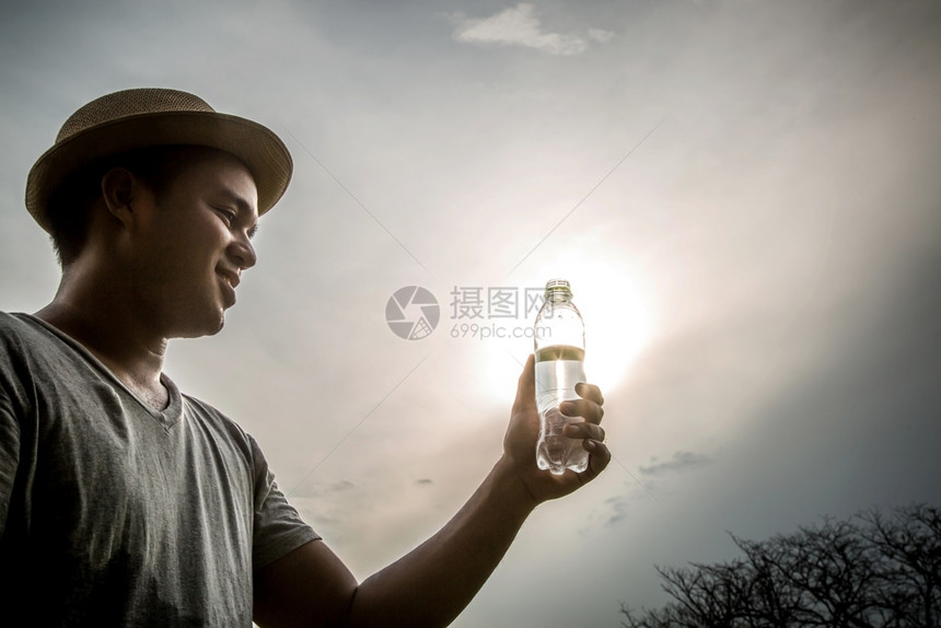 男人新鲜的喝瓶装水户外阳光明灯双后活动图片