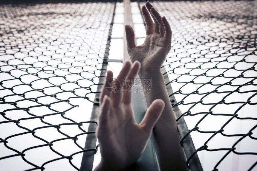 超过多样郁闷沮丧麻烦帮助和无望的妇女通过连链栅栏求助举起手来图片