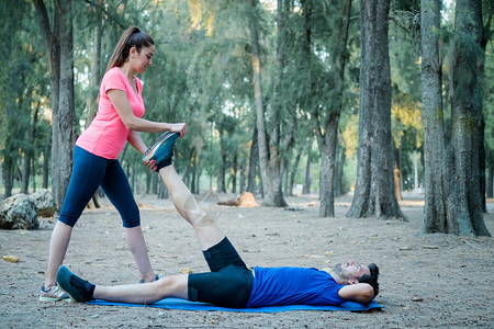 白种夫妇在公园里做伸展运动积极的瑜伽教练员图片