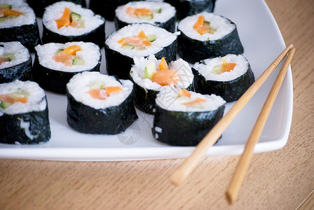 白盘上美味的自制寿司午餐紫菜棍子图片