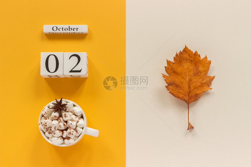 浅褐色的10月2日Wooden日历10月2黄蜂底的含棉花糖和黄秋叶的可杯上面有棉花糖和黄蜜蜂底的色秋季叶子FlatMomocku图片