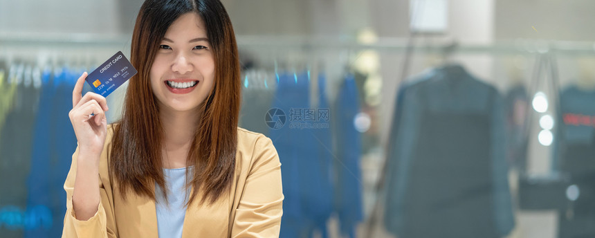 数字的复制互联网持有并展示信用卡供在服装店商的百货技术资金钱包和网上支付概念信用卡模型上在线购物的亚洲妇女银行家名单Abanne图片