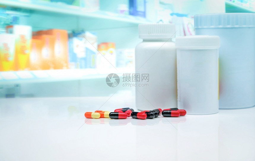 药店背景模糊物展示架上的白色柜台药瓶胶囊丸制业保健和医学概念处方药橙理维生素图片