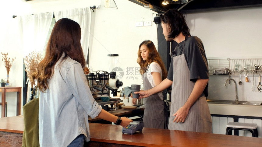 亚洲女进行数字支付亚洲女孩在咖啡店通过智能手机进行非接触式支付咖啡馆背景小企业金融和数字非接触式支付概念银行业制作亚洲人图片