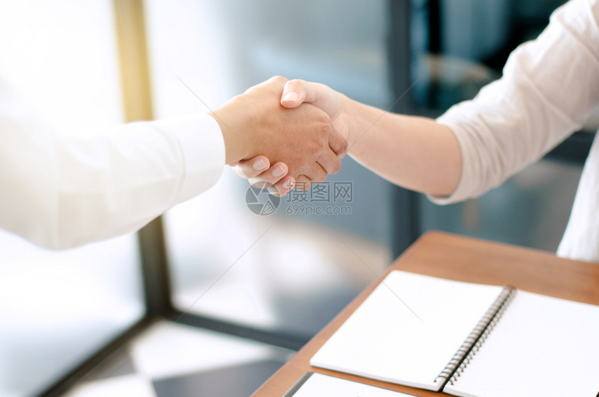 同事在办公室握手颤抖在办公室工作快乐的人们公司图片