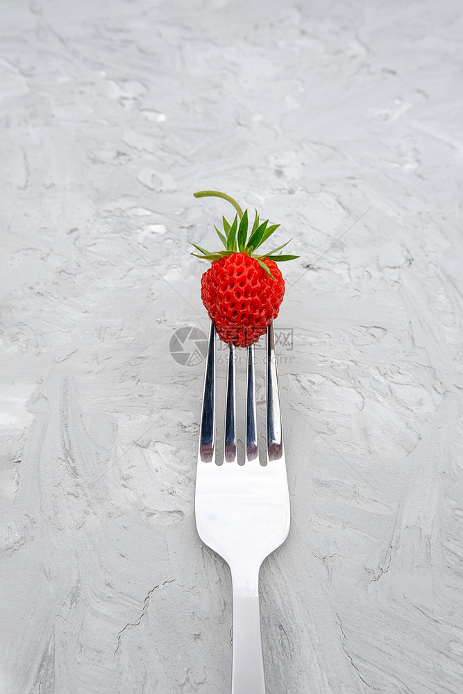 最小的好吃维他命灰色石桌背景叉上的红熟草莓带复制空间概念减肥食品或素主义最小风格顶视图灰色石桌背景叉上的红色成熟草莓带复制空间图片
