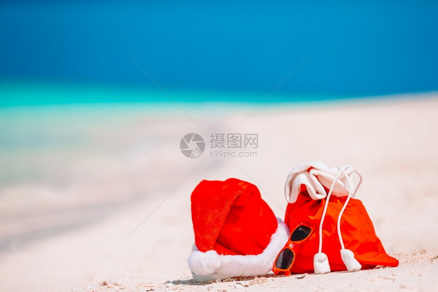 眼镜景观红色圣诞老人包和帽子在海滩上的特写天堂图片