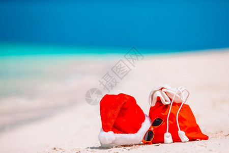 眼镜景观红色圣诞老人包和帽子在海滩上的特写天堂图片
