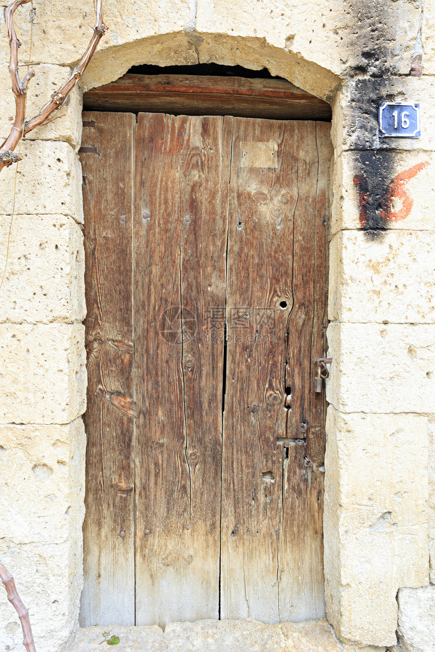 装饰风格铆钉优质的古老有风气木门里面有金属铁制锁嵌在由石制成的旧墙壁中木制门上面有铁锁图片