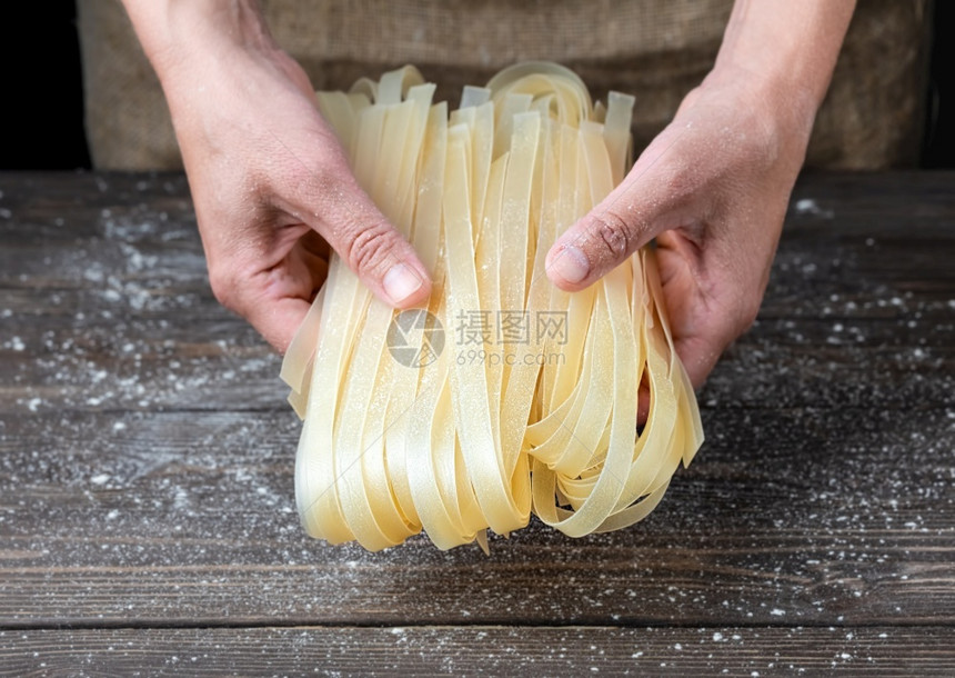 意大利美食中央人体女手握熟面在家煮近身深木本底面粉分散在桌子上女手握熟面图片