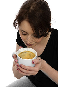穿着黑衬衫的年轻漂亮女孩在杯子里闻着咖啡喝吸引人的女肖像图片