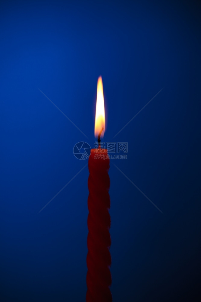 季节蓝背景的一丝扭曲燃烧蜡烛传统橙图片