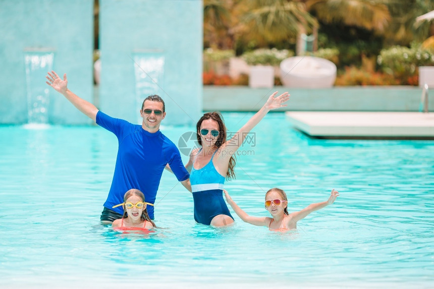 白种人肖像在游泳池度假的年轻家庭快乐四口人一起度海滩假阳光图片