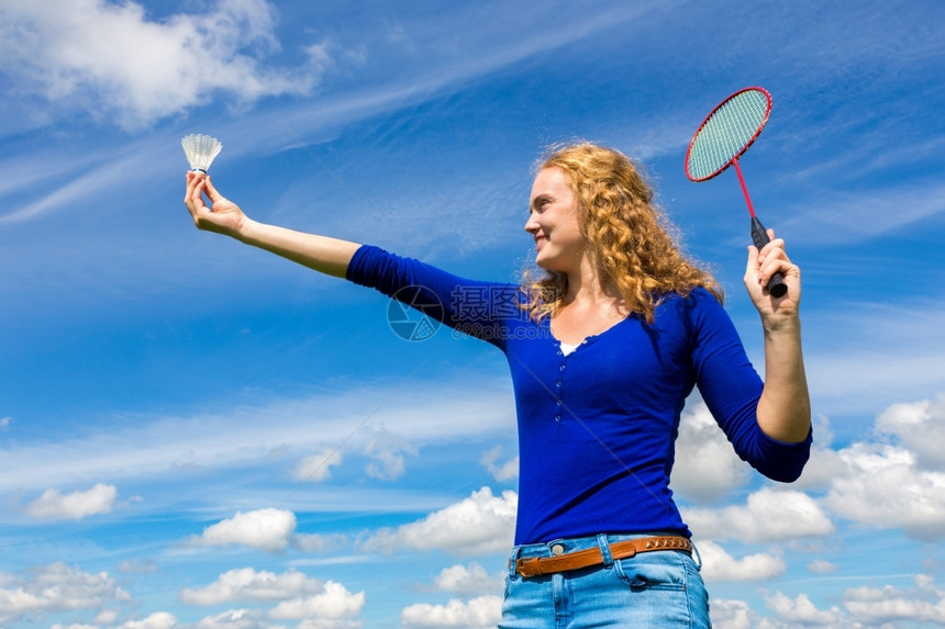 常设抓住女士年轻的天主教女青年穿梭和羽毛球与白云对着蓝天图片
