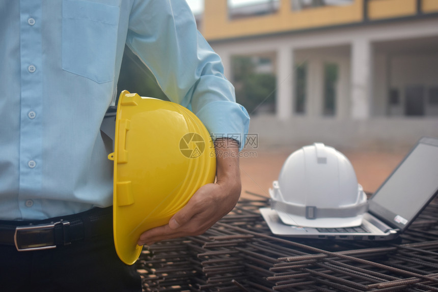 建设者家商业工程公司拥有安全坚固的硬帽工作大楼建筑项目工程师持有头盔建筑物地产背景单位美元图片