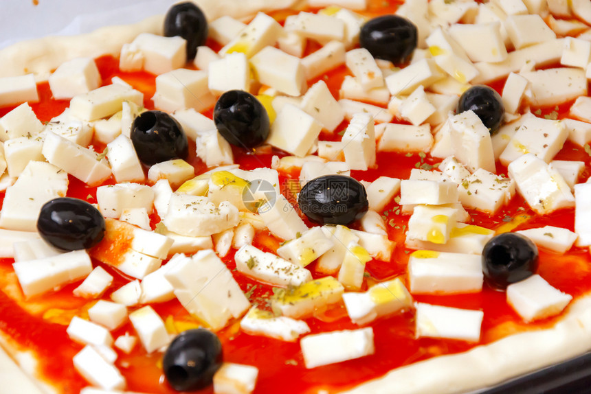 素食主义者糕点烹饪原披萨黑橄榄和番茄酱已做好烘烤准备图片