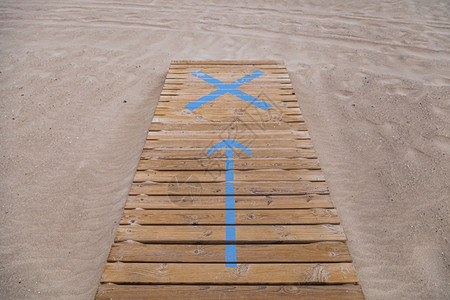 木板路指着海滩入口处的木制行道上箭头标志物人行天桥旅图片