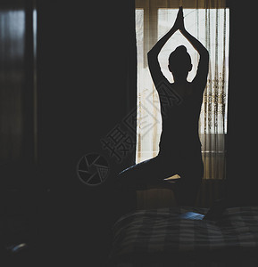 体式快乐的一种妇女在卧室内做瑜伽姿势在家保持身体健康精神图片