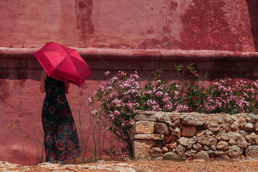 裙子年轻寂寞的姑娘拿着红色雨伞保护自己免受太阳的照射就在红古城堡旁边市夏天图片