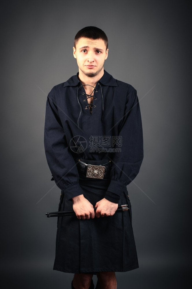 年轻鼓手穿着黑苏格兰服装手里拿着棍棒的黑人苏格兰装扮鼓手男生模型现代的图片