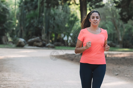 锻炼年轻的白女人在公园里微笑着奔跑健康图片