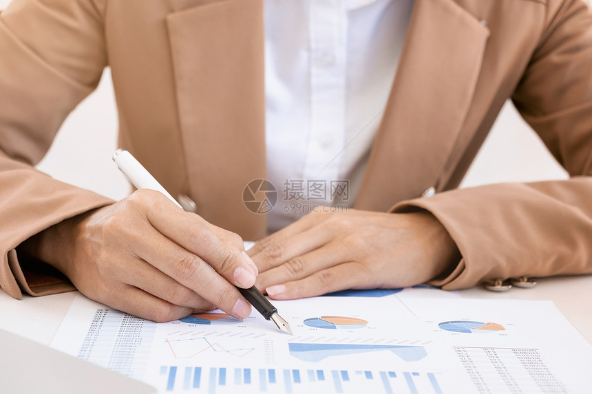 在办公服务台与销售报告一起工作的业绩分析员办公室服务台的销售报告数据金融图表图片