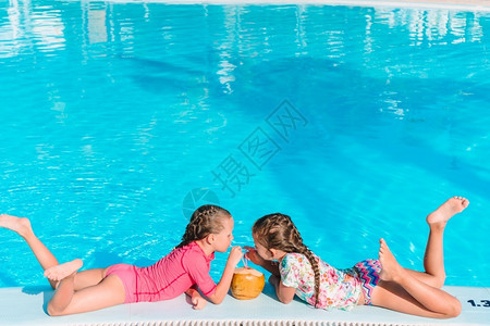 小女孩在室外游泳池玩耍图片