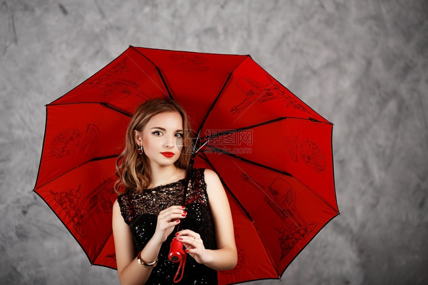 身着黑色晚礼服和红伞式雨的年轻姑娘身着红色伞式雨的年轻女士孩吸引人的图片