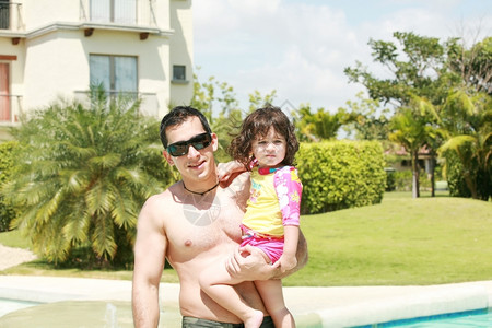 微笑父亲和女儿在游泳池旁边的父母巴拿马图片
