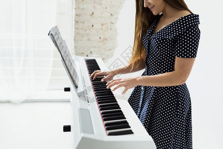 声音的玩特写微笑年轻女钢琴手图片